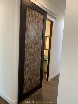 Dark stained alder wood barn door with a woven look 3form resin panel