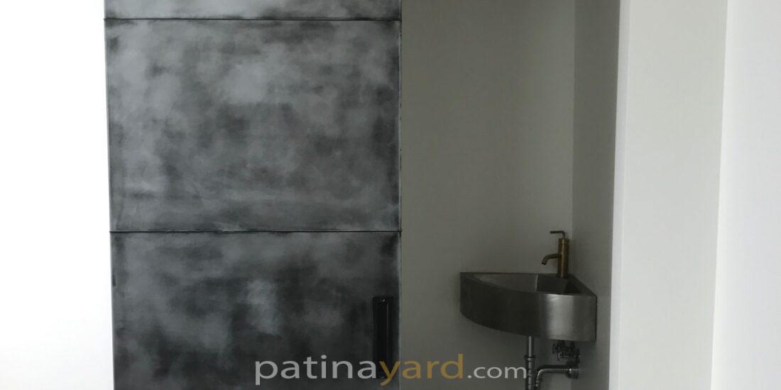 pure zinc panel barn door with an antique black patina finish