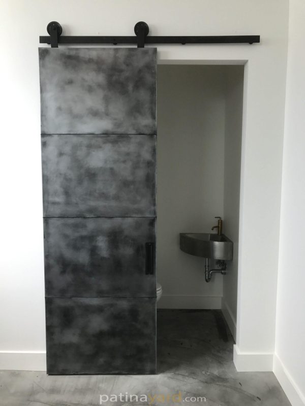 pure zinc panel barn door with an antique black patina finish