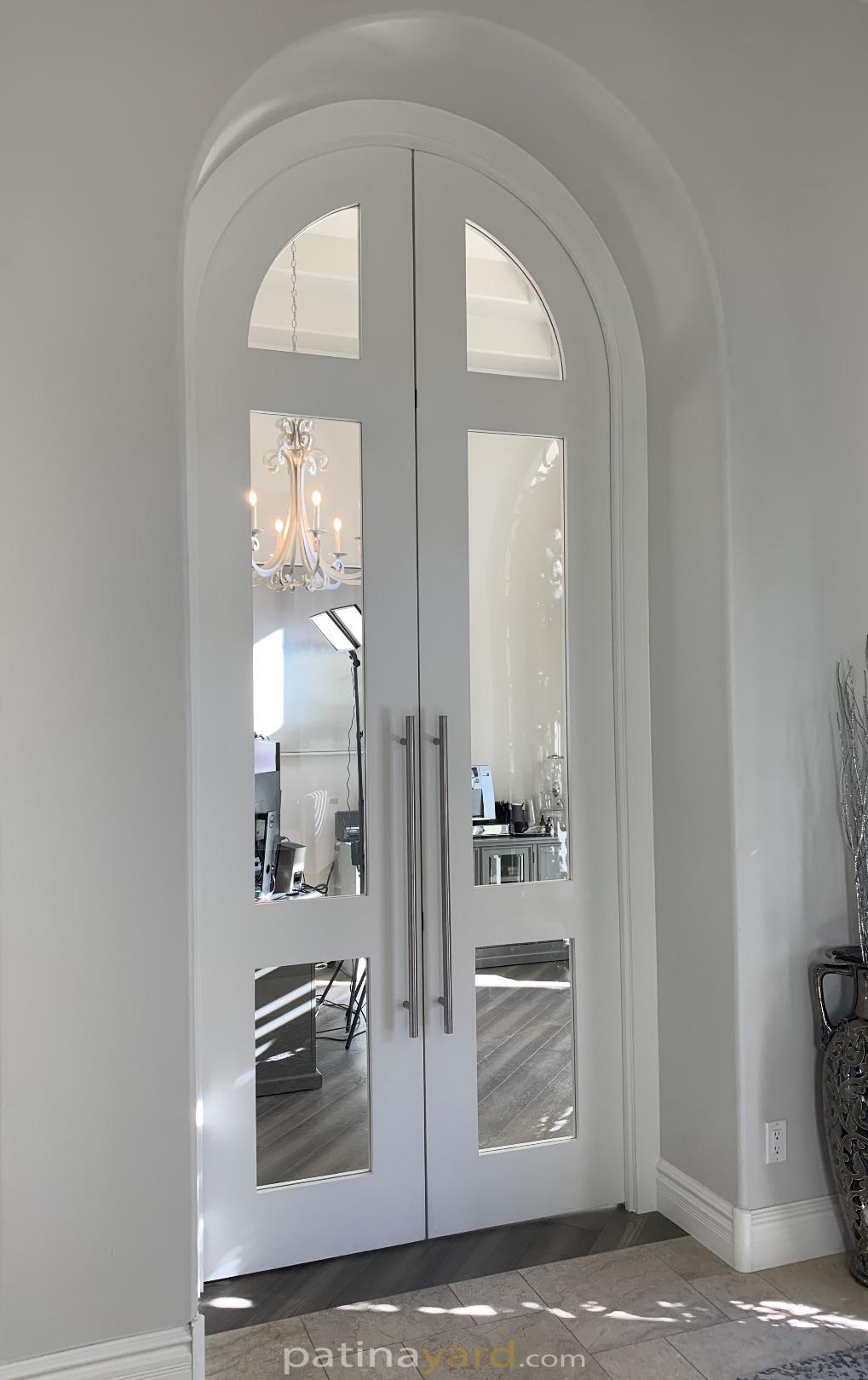 Large arched double painted doors with clear glass