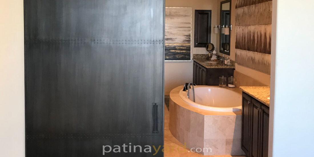 metal barn door with a patina finish and custom hardware