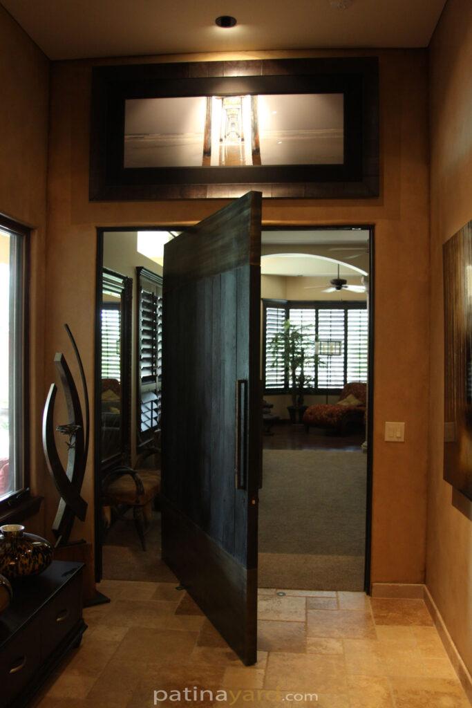 Shou Sugi Ban Pivoting door with patina steel