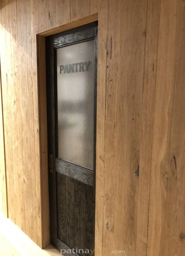 Stained white oak pantry pocket door with textured glass