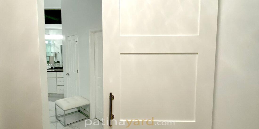 painted white shaker style barn door with stainless steel hardware