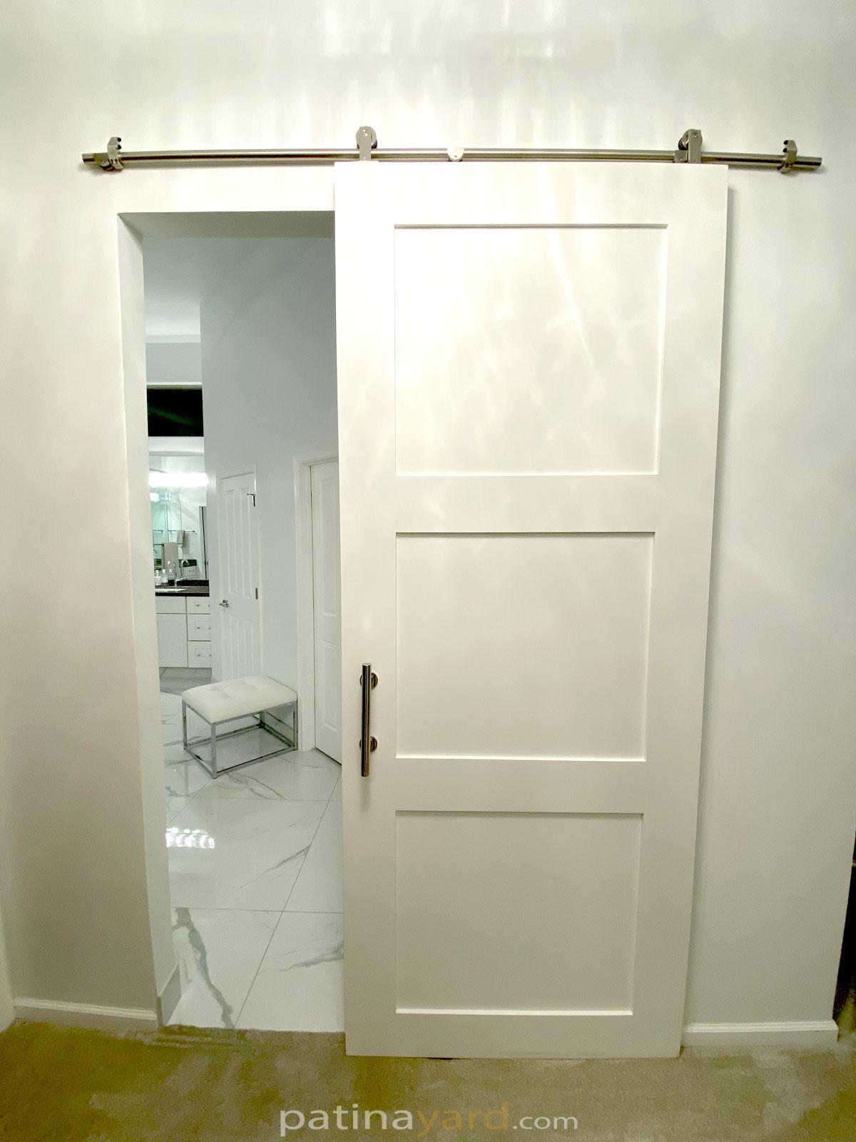 painted white shaker style barn door with stainless steel hardware