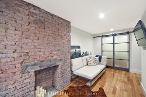 warehouse style double doors Warehouse style double steel and glass barn doors in a New York loft living room with a brick fireplace