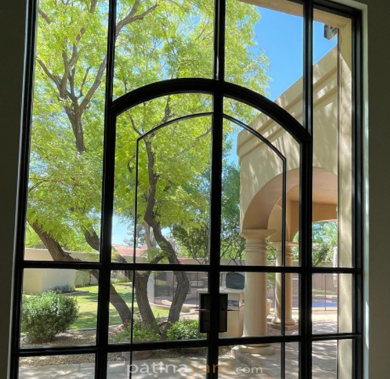 Exterior metal and glass doors with an arch overlay.