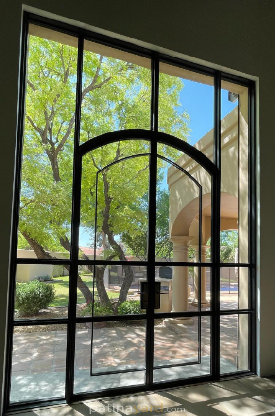 Exterior metal and glass doors with an arch overlay.