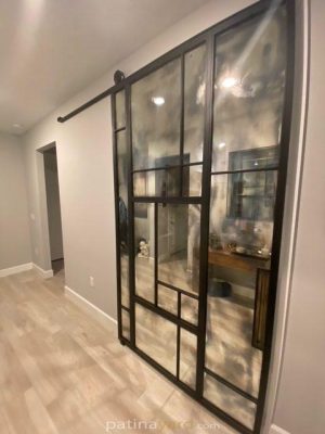 Random Pattern Antique and Metal Barn Door Antique mirror and metal barn door sliding along a hallway wall