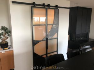 Artsy Metal and Satin Glass Doors Artsy metal and glass doors on a track in a living room