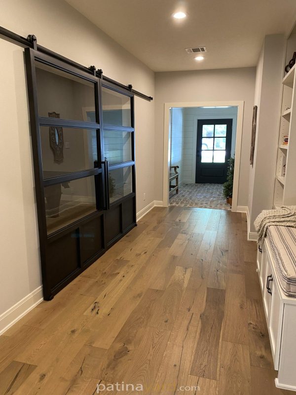 Double Steel and Glass Barn Doors Double steel and glass panel sliding barn doors in a hallway
