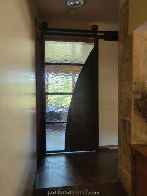 Metal and Glass with Arch Barn Door Industrial contemporary steel and specialty glass door with a curved dark metal panel