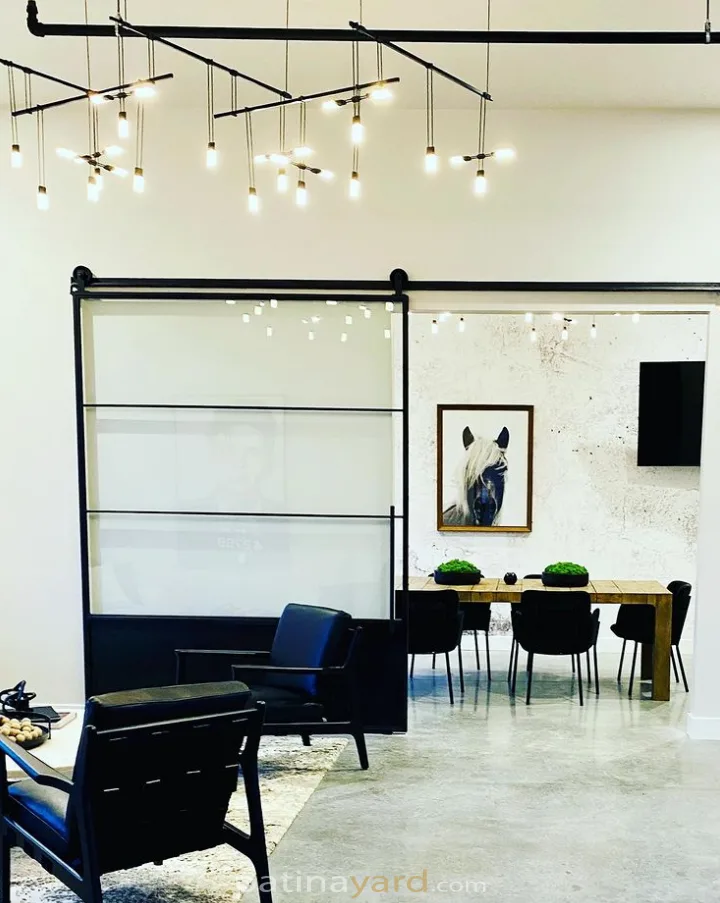 Large metal and glass sliding barn door in an open office space