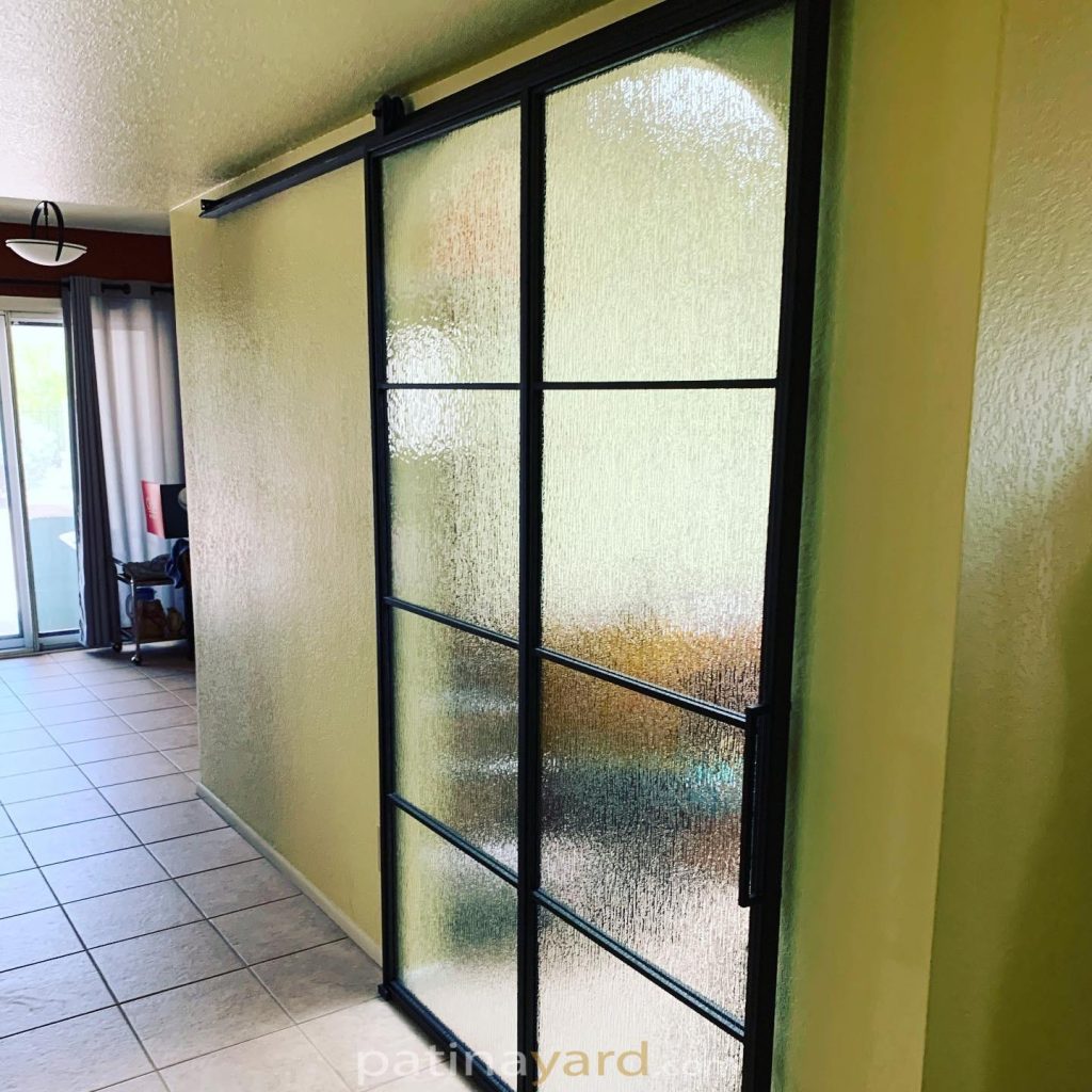 Metal and rain glass barn door sliding in a hallway