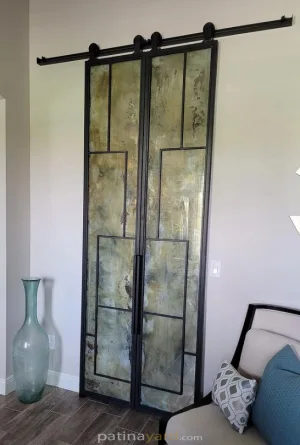 Sliding Metal and Antique Mirror Barn Doors Sliding metal and antique mirror barn doors beside a sitting area