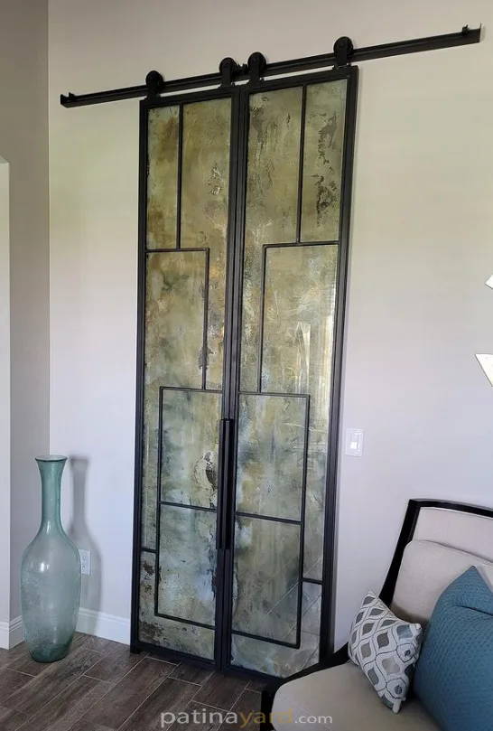 Sliding metal and antique mirror barn doors beside a sitting area