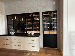 Patina black metal and glass bi-folding windows and door beside a bar and wine display