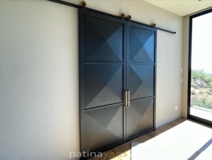 3-D Metal Barn Doors Double sliding black steel barn doors with three dimensional pyramid panels and brass pulls