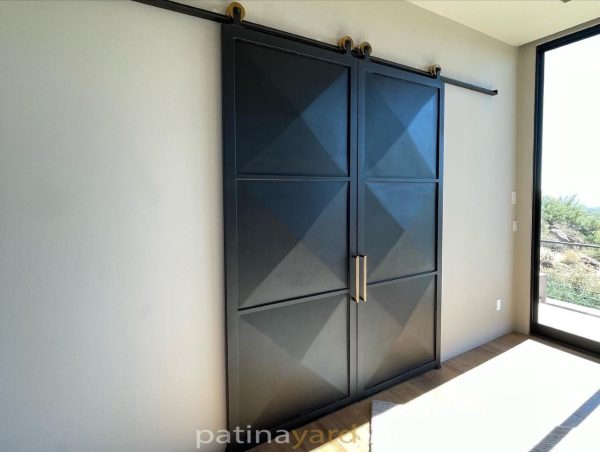 3-D Metal Barn Doors Double sliding black steel barn doors with three dimensional pyramid panels and brass pulls