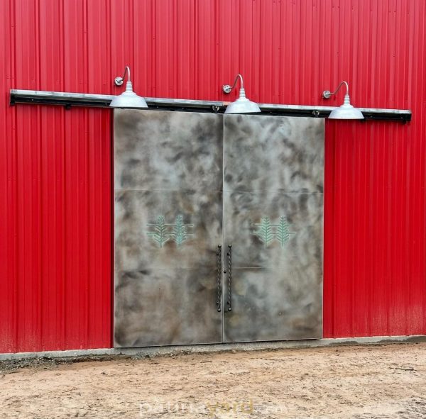 Aluminum doors Aluminum barn doors with a patina finish on a building with red metal siding