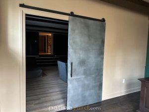 Three panel zinc barn door with a pale blue-gray finish