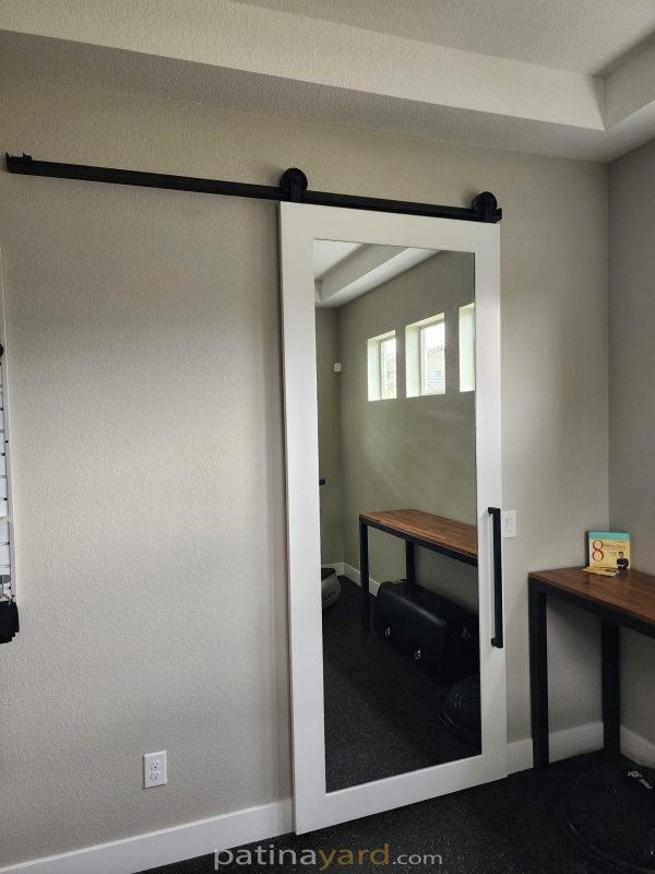 White painted shaker barn door with a full length mirror panel