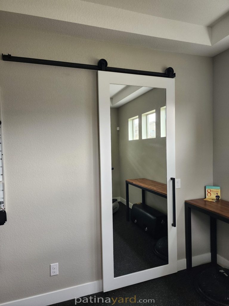 White painted shaker barn door with a full length mirror panel