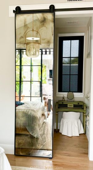 Antique barn door Beautiful antique mirror barn door beside a bathroom with a window