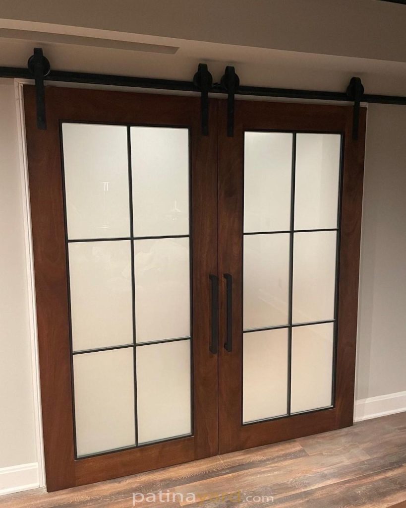 Mahogany double barn doors with blackened metal frame with glass