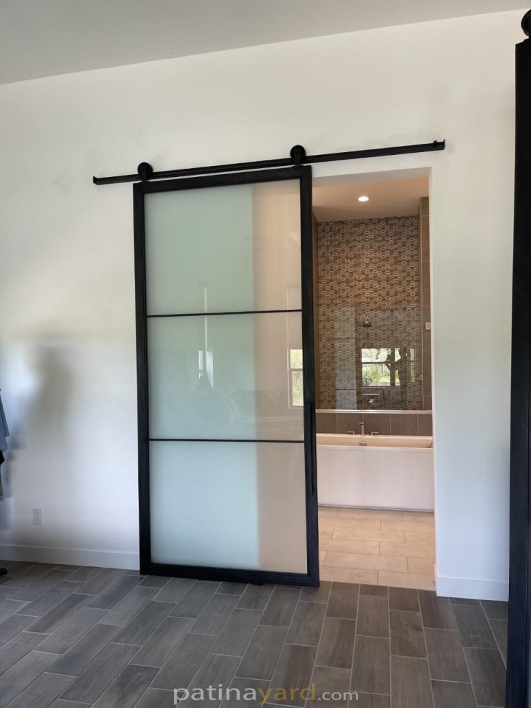 Metal and satin glass barn door on a black track