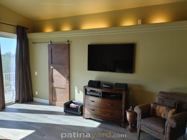 Wood stained Shaker style barn door in a living room