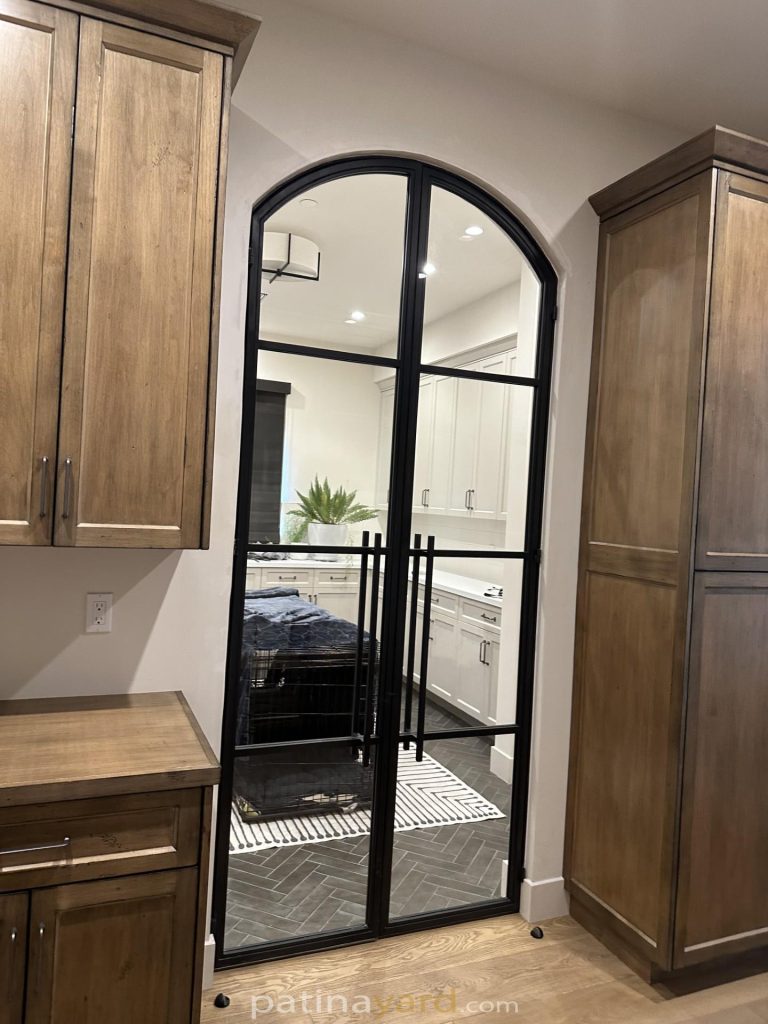 Arched double blackened metal and clear glass hinged doors