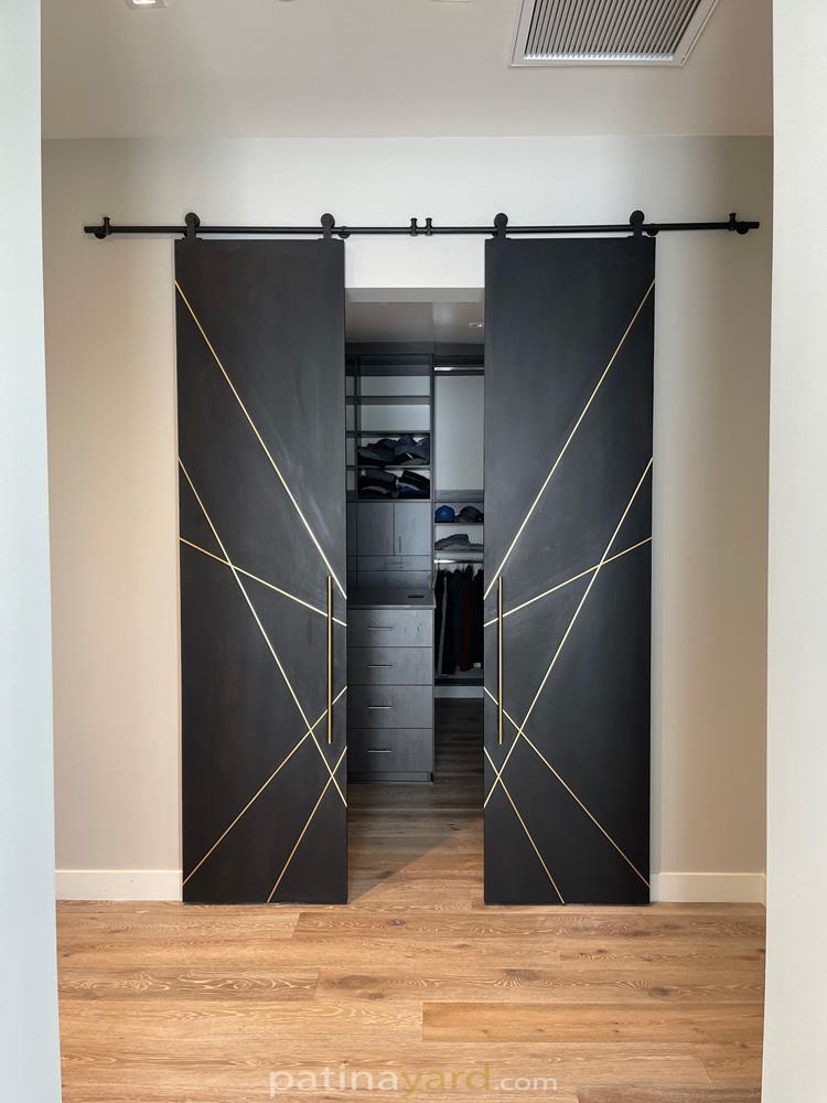 blacken oak sliding barn doors with brass inset.
