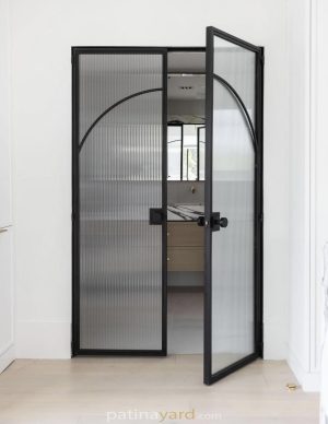Reeded glass double entry doors to master bath with blackened metal frames