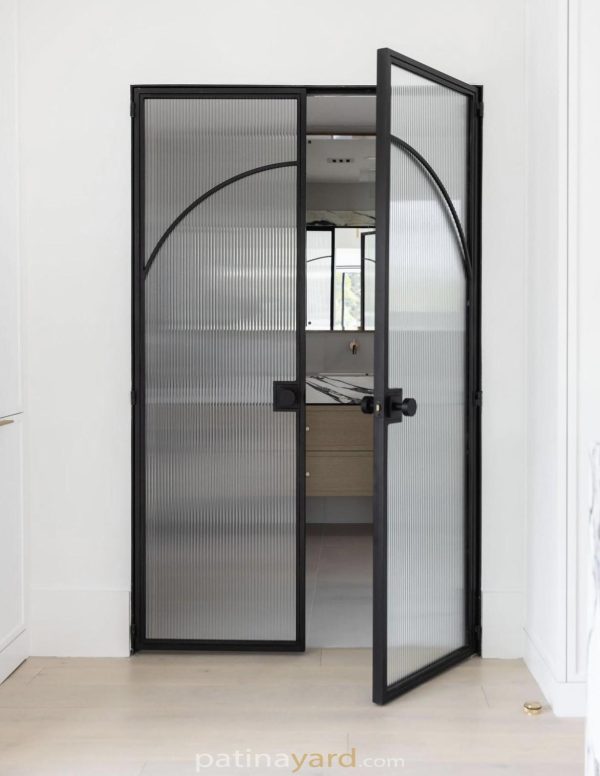 Reeded glass double entry doors to master bath with blackened metal frames