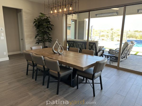Ash wood dining table with a black metal base and gray chairs