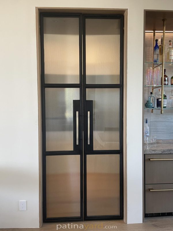 Reeded glass double flush pocket doors made of blackened metal