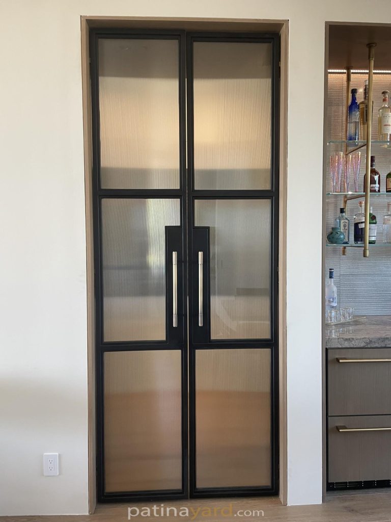 Reeded glass double flush pocket doors made of blackened metal
