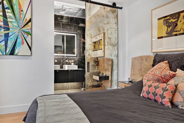 Konstantin Antique full length mirror barn door in a bedroom beside a bathroom doorway