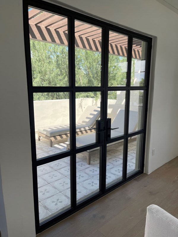 Black metal and glass back entry doors with a grid of glass panes