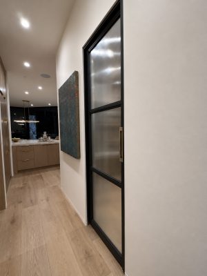 blacken-metal-and-fluted-glass-pocket-door Black metal frame and fluted glass pocket door and brass hardware