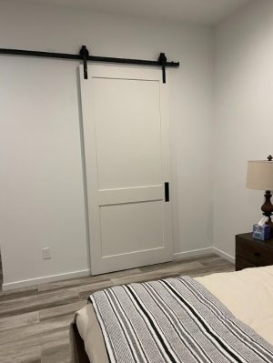 2 Panel Shaker Style Barn Door White 2 panel painted shaker style barn door in a bedroom