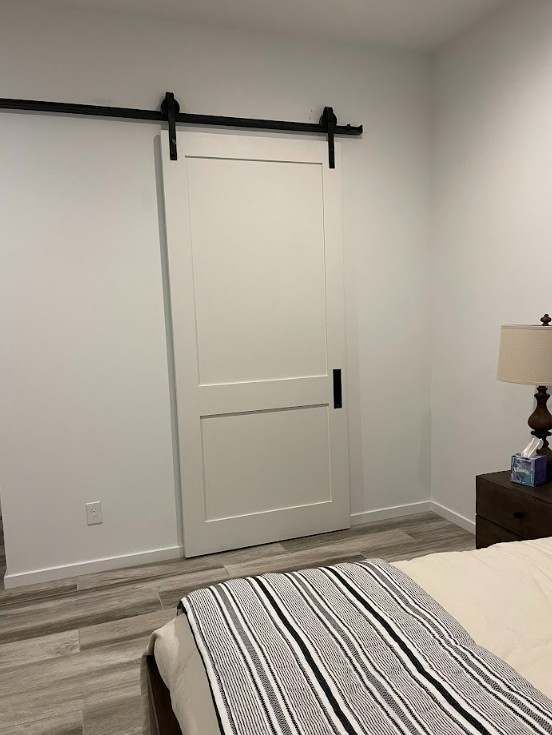 White 2 panel painted shaker style barn door in a bedroom