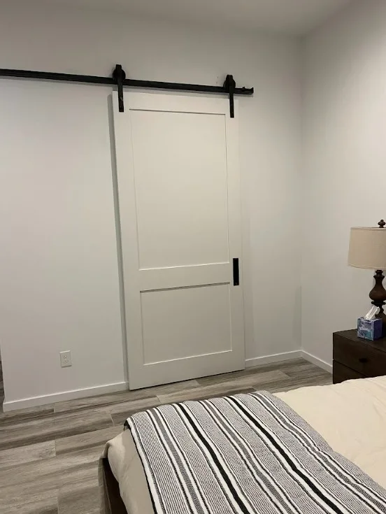 White 2 panel painted shaker style barn door in a bedroom