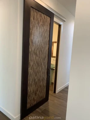 Dark stained alder wood barn door with a woven look 3form resin panel