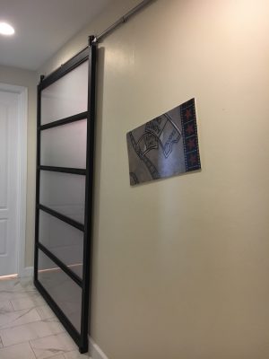 5 Panel Industrial Contemporary Steel and Glass Barn Door Five panel black steel and satin glass barn door in a hallway