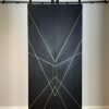 Black stained white oak double barn doors closed showing the diagonal brass inlay pattern