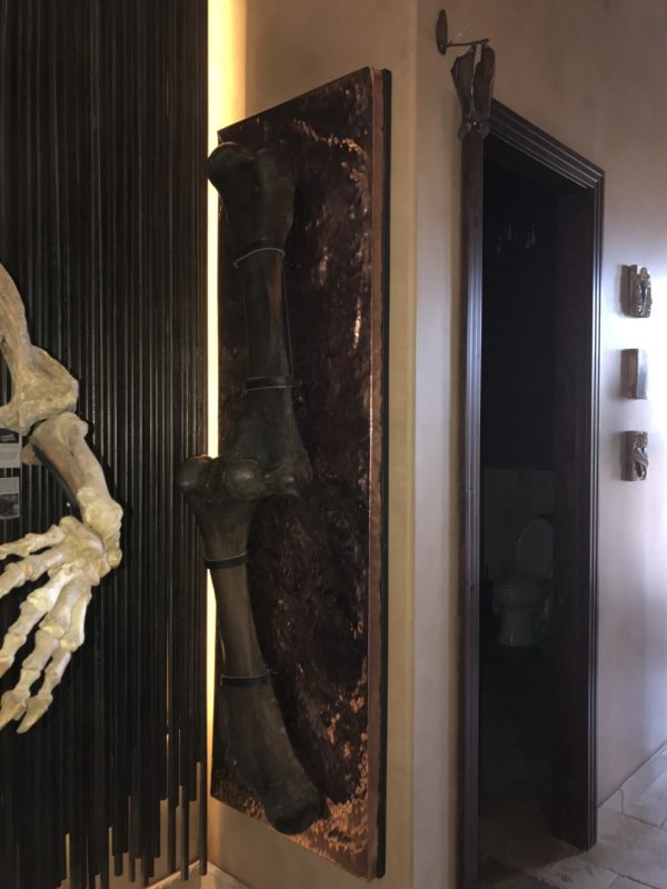 Hammered copper wall art piece displaying a large bone