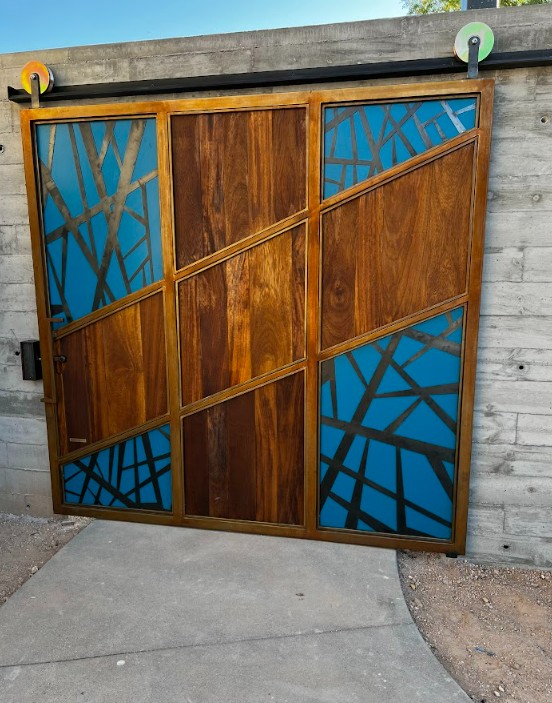 Exterior barn door with a metal frame, blue painted panels with metal overlay and wood center panels