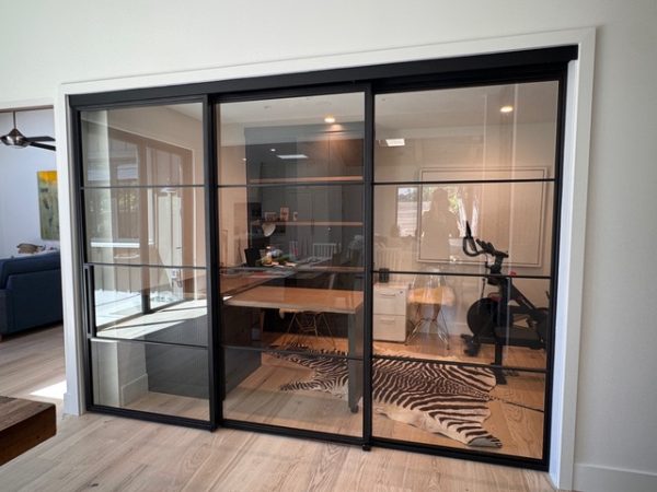 Black steel and glass stacking sliding doors on a concealed upper track enclosing a home office in Walnut Creek, California